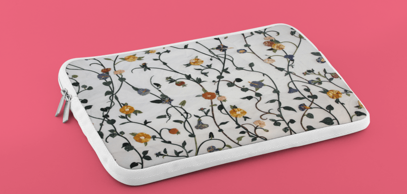 Laptop sleeve mockup on pink background with editable fabric design and color options via PlaceIt generator.