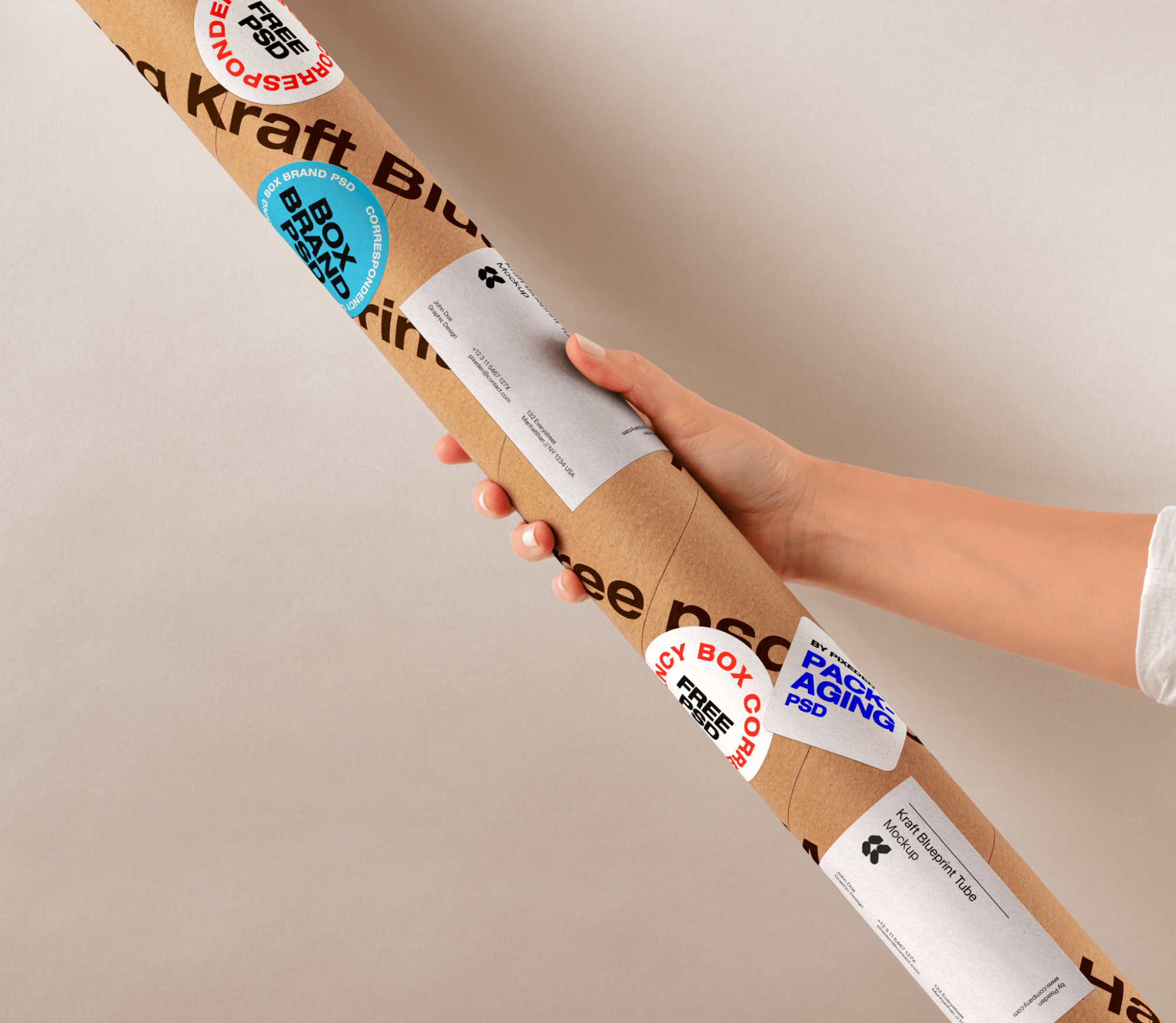 Hand holding a kraft tube with customizable labels and stickers mockup against a neutral background.