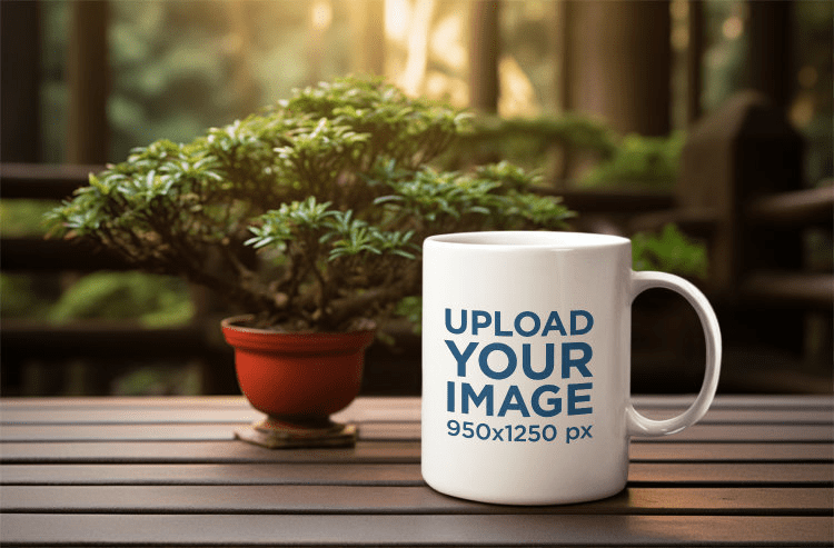 White coffee mug mockup with a plant on a wooden table.