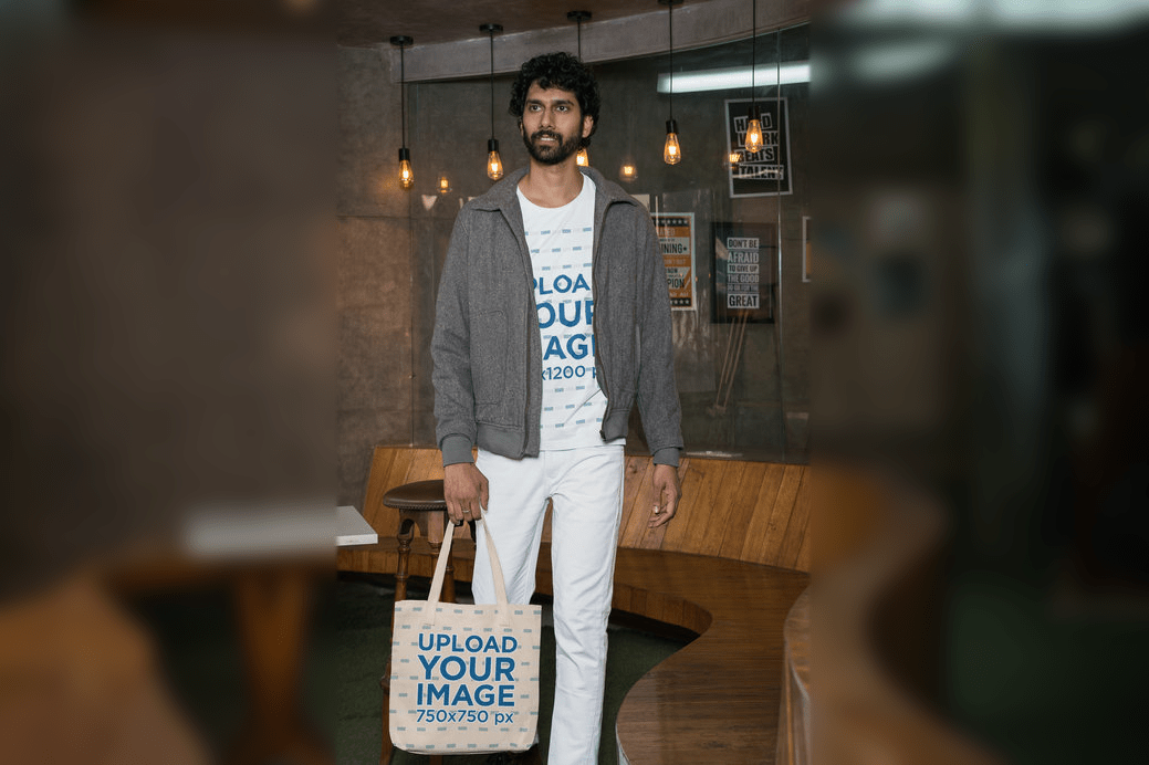 A photorealistic mockup of a bearded man wearing a Gildan t-shirt and carrying a sublimated tote bag.