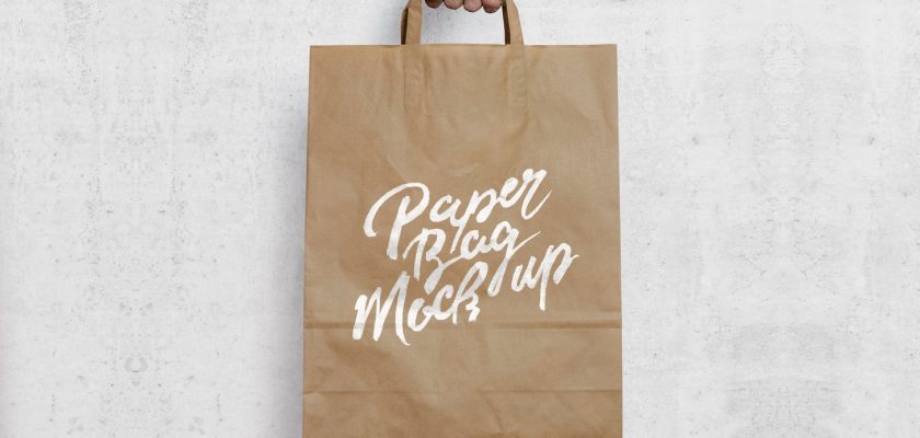 Free paper shopping bag mockup PSD &mdash; kraft bag held in hand