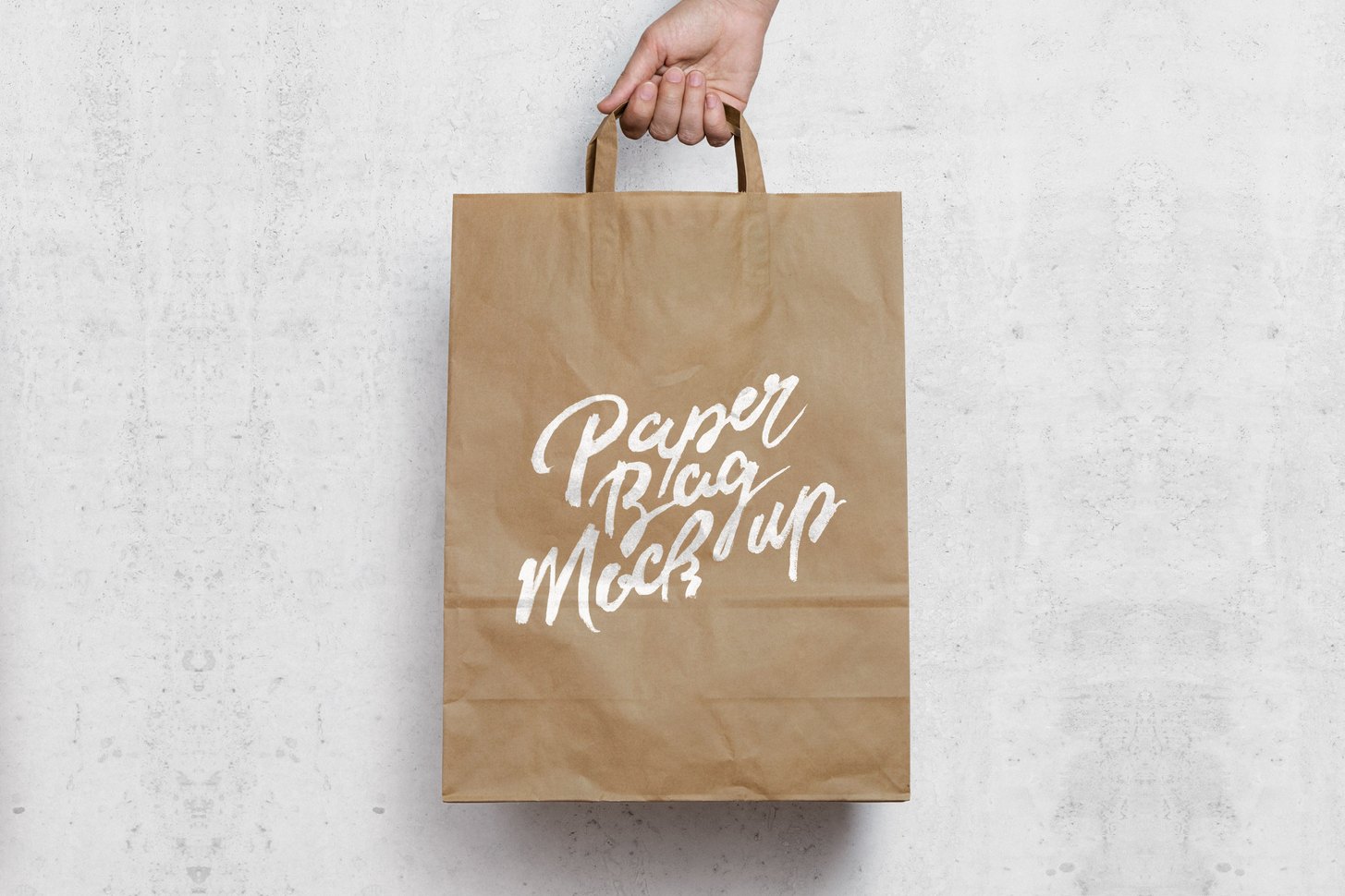 Free paper shopping bag mockup PSD &mdash; kraft bag held in hand